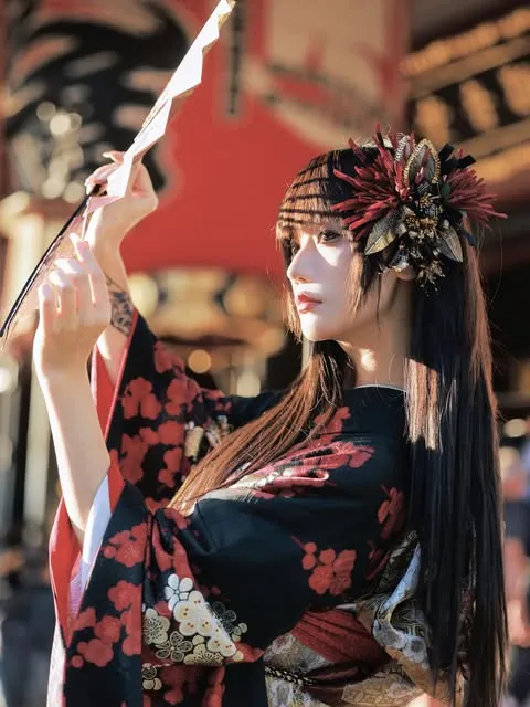 Side portrait in Asakusa of a black and red floral furisode with a large hair ornament